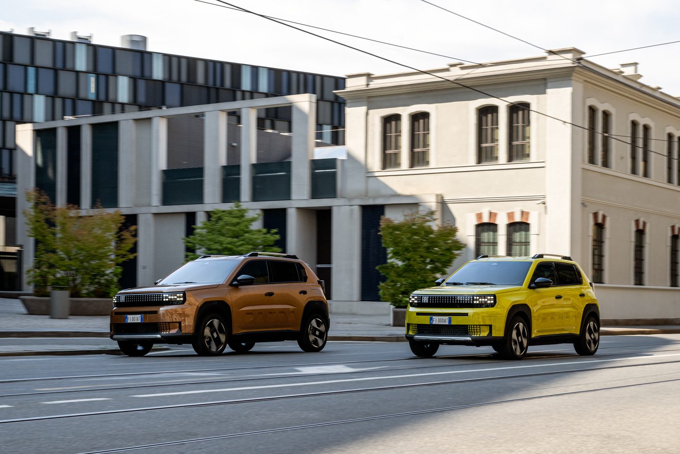 Two FIAT Grande Panda cars on a city street with tram tracks